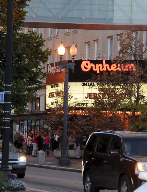 A street scene with cars and a theater marquee reading 